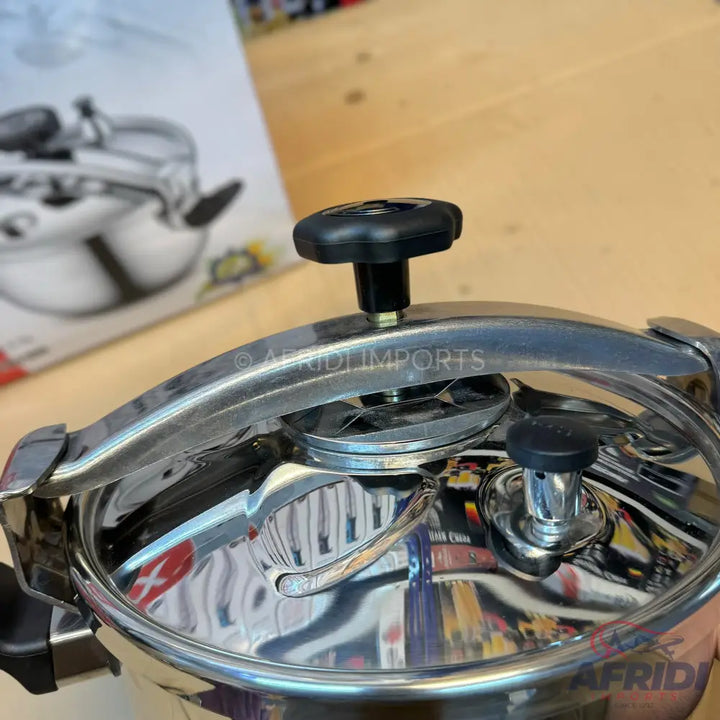 A shiny stainless steel pressure cooker with a black knob and handle.
