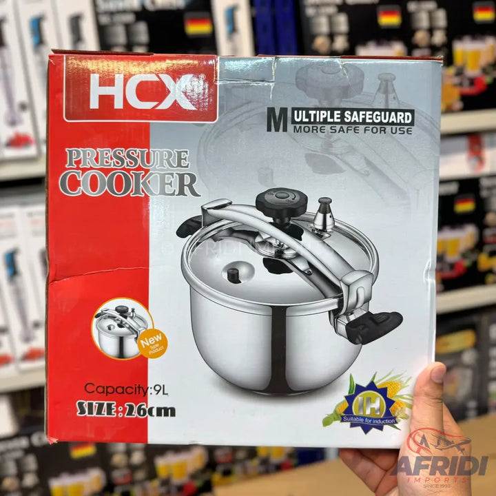 A boxed HCX pressure cooker with a 9L capacity and 26cm size, featuring multiple safeguards for safe use.