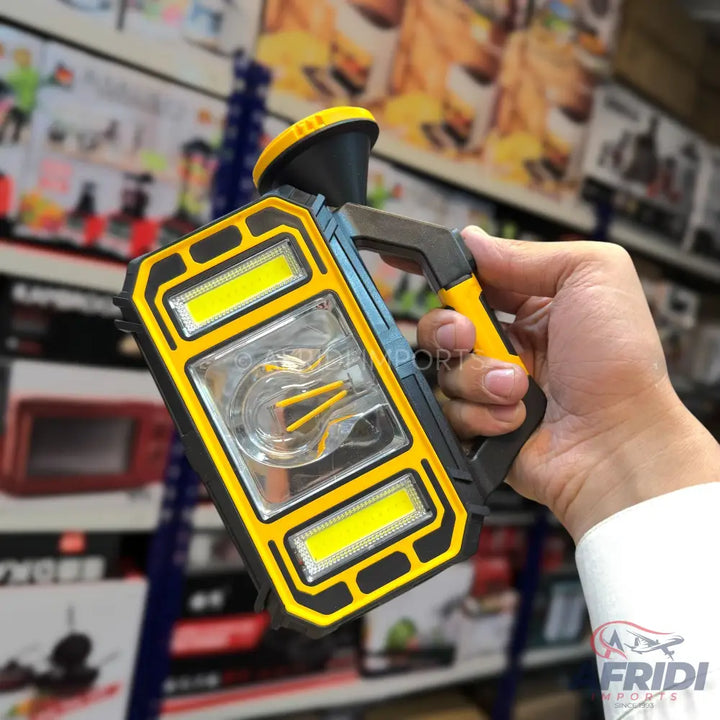A handheld, yellow and black work light with multiple LED panels and a top-mounted spotlight.