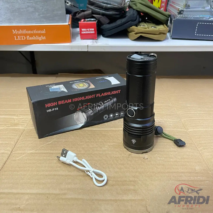 Black high-beam highlight LED flashlight with a USB charging cable and packaging.