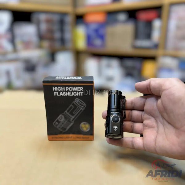 Black, high-power, compact flashlight with a clip.