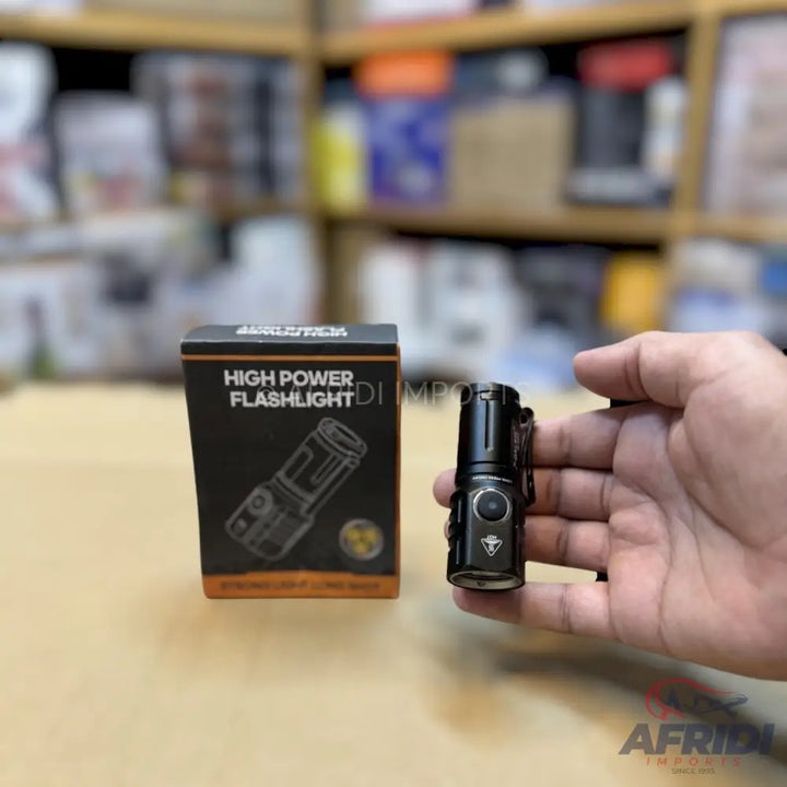Black, high-power, compact flashlight with a clip.
