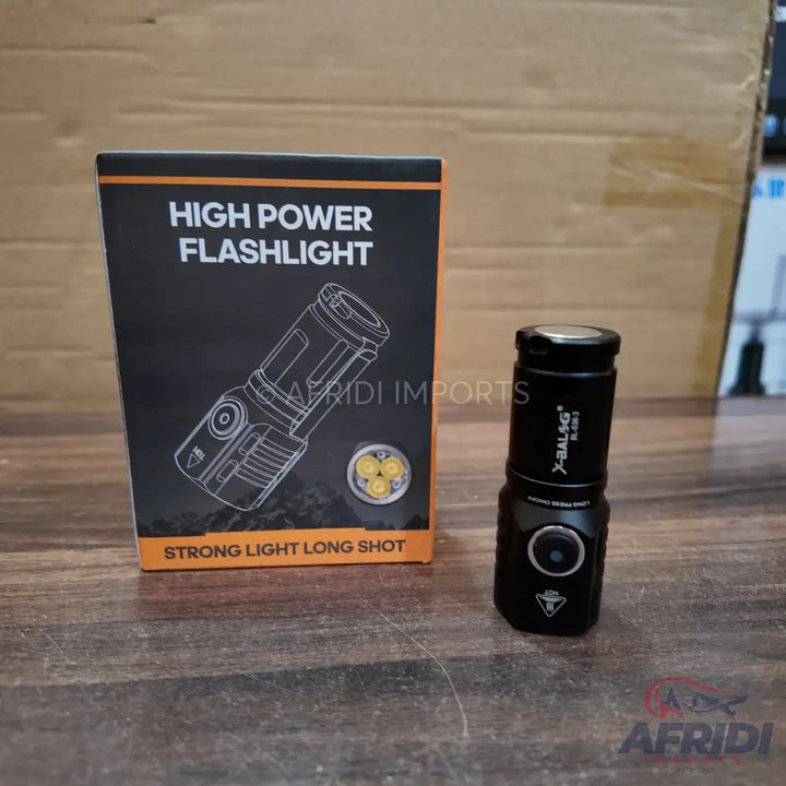 Black high-power flashlight with a triple-LED design, packaged in a box indicating ’strong light long shot’.