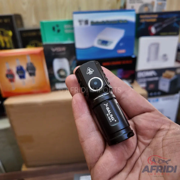 A black tactical flashlight with a side button and a heat warning symbol.