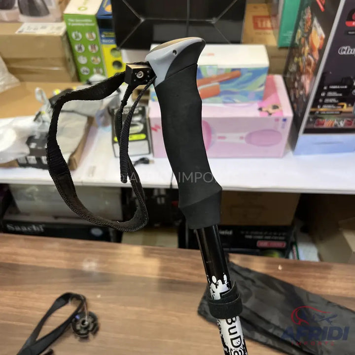 Black and gray hiking pole with an adjustable wrist strap.
