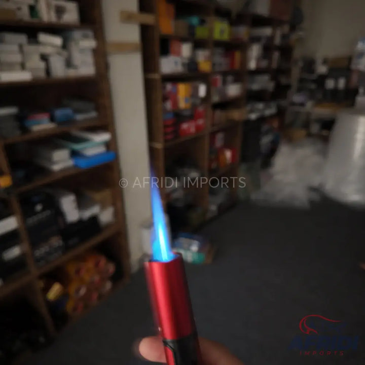 Red metal torch lighter with a blue flame.
