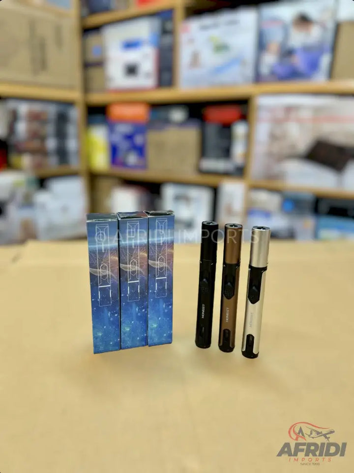 Three sleek, futuristic-looking lighters in black, bronze, and silver, alongside three matching, galaxy-themed boxes.