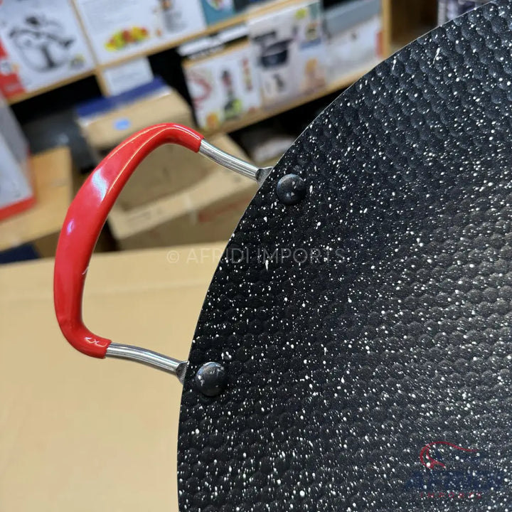 Black non-stick frying pan with a red handle.
