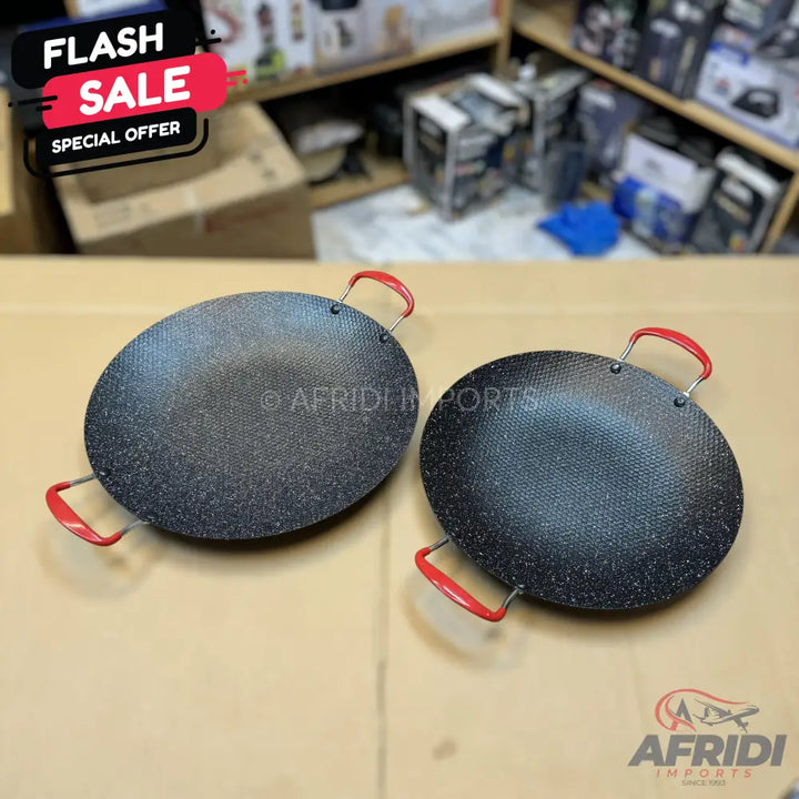 Two round, black, speckled non-stick cooking pans with red handles.