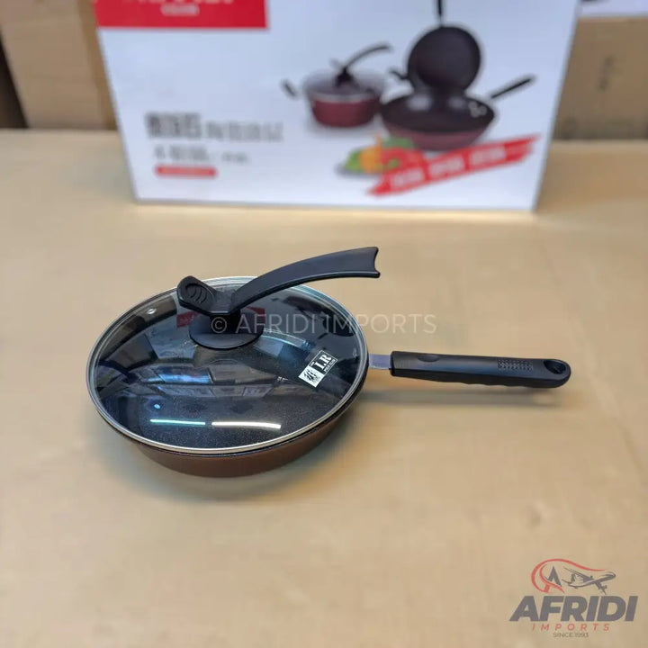 A brown non-stick frying pan with a black handle and a clear glass lid.