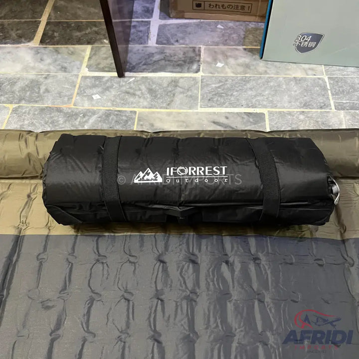 Black rolled-up sleeping pad with straps.