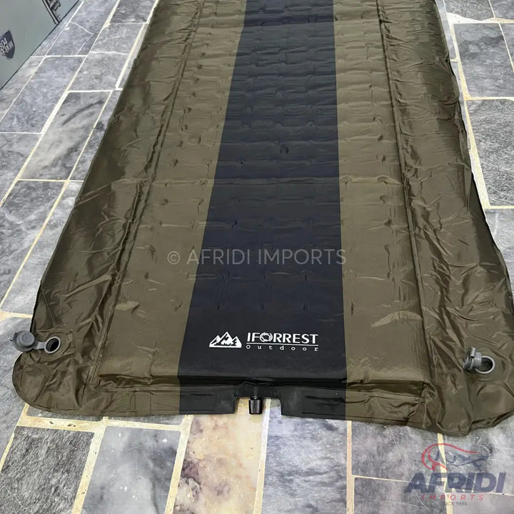 An olive green and black outdoor sleeping pad with inflation valves.