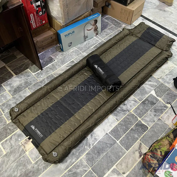 An olive green and black striped self-inflating sleeping pad with a rolled-up carrying bag.