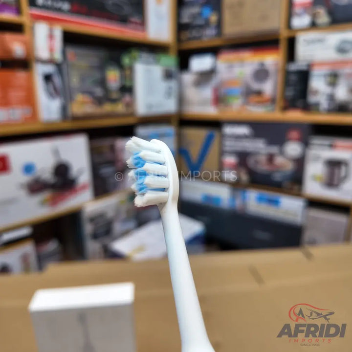 White electric toothbrush with blue and white bristles.