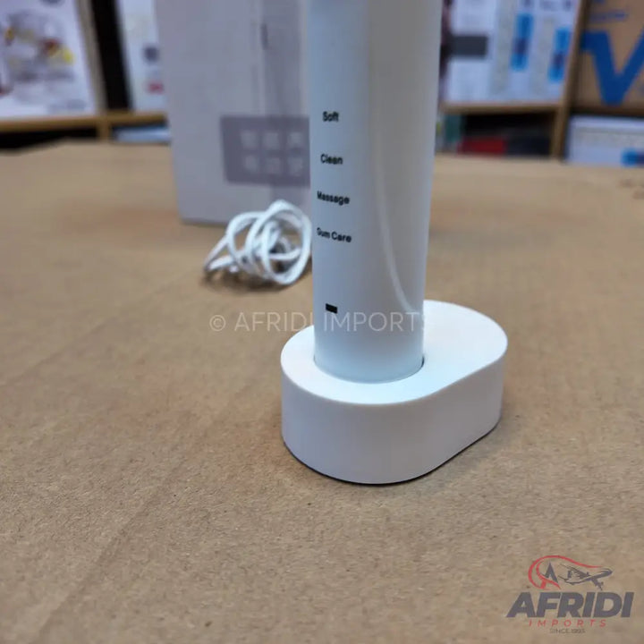 White handheld device with a charging base for skin care, featuring settings for Soft, Clean, Massage, and Skin Care.