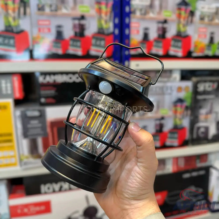 A black, solar-powered outdoor lantern with a motion sensor.