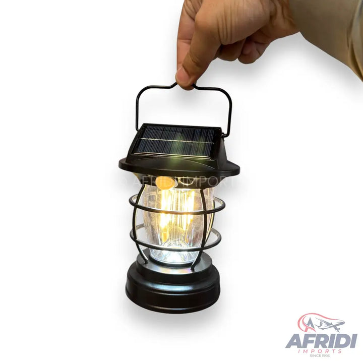 A black solar-powered outdoor lantern with a glowing light bulb.
