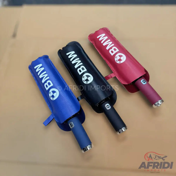 Three compact, foldable umbrellas in blue, black, and red, each with a silver tip.