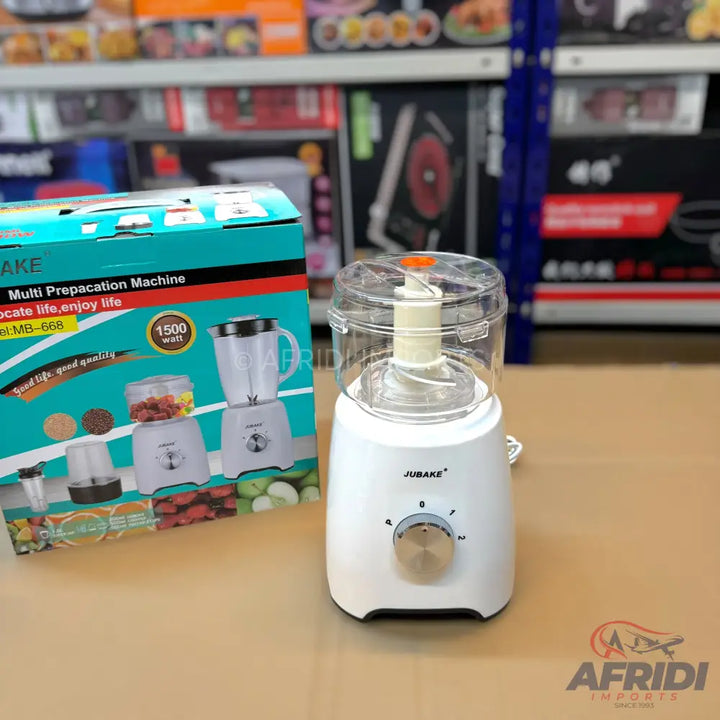 A white electric food chopper with a clear plastic lid and a silver control knob, accompanied by its teal and black packaging box.