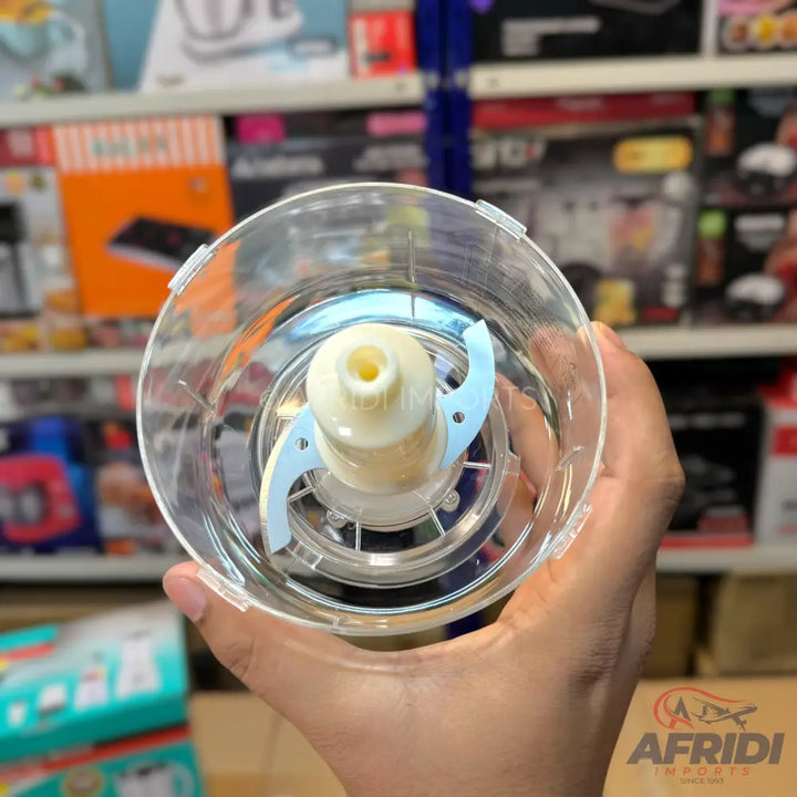 A clear plastic food chopper container with a two-bladed rotating mechanism.