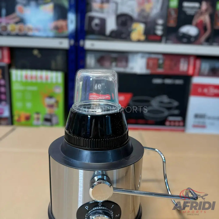 A stainless steel electric blender with a transparent plastic grinding cup.