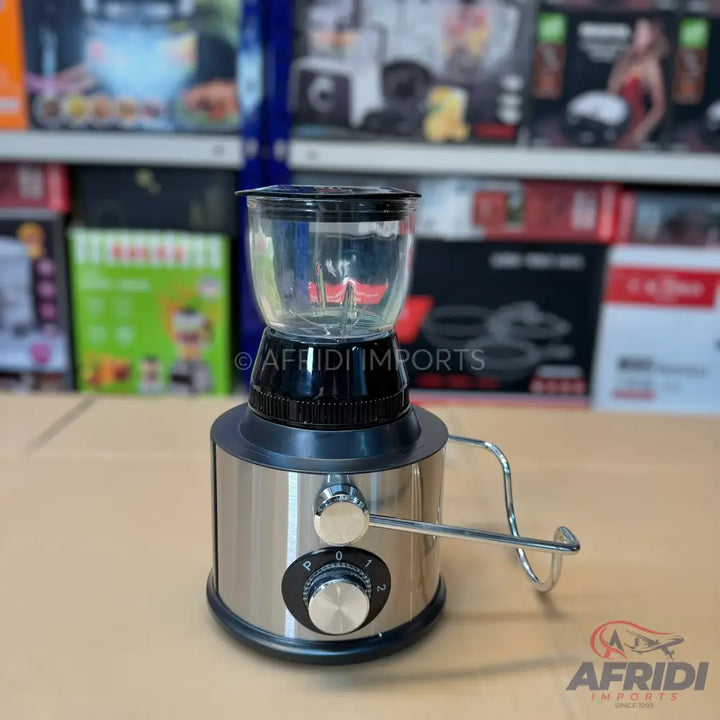 A modern, stainless steel blender with a clear plastic jar, a speed dial, and a handle.