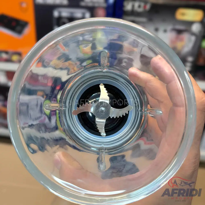 A clear glass blender jar with a four-pronged stainless steel blade assembly.