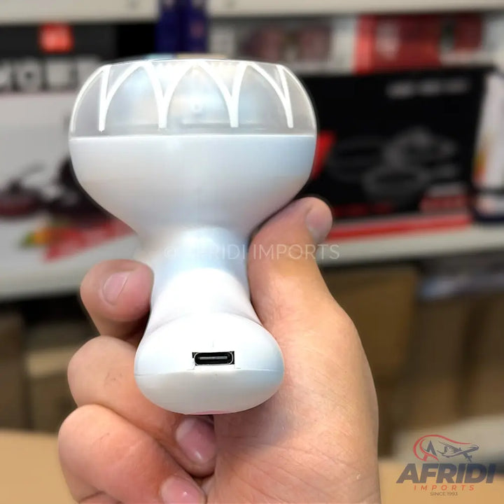 White handheld fan with a translucent, decorative top and a micro-USB charging port at the base.