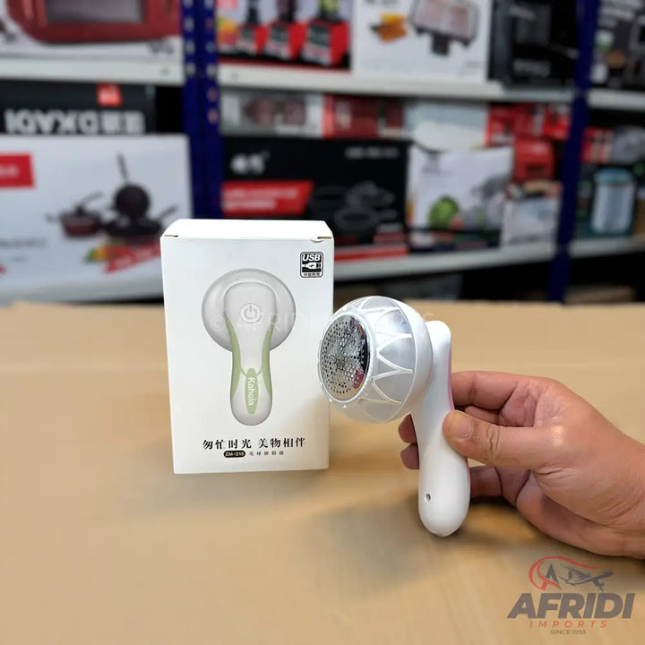 White electric lint remover with a clear plastic cover over the blade.