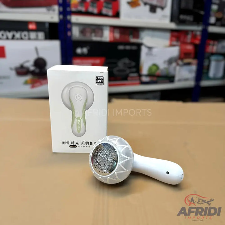 White electric lint remover with a USB charging port and a textured spherical head.