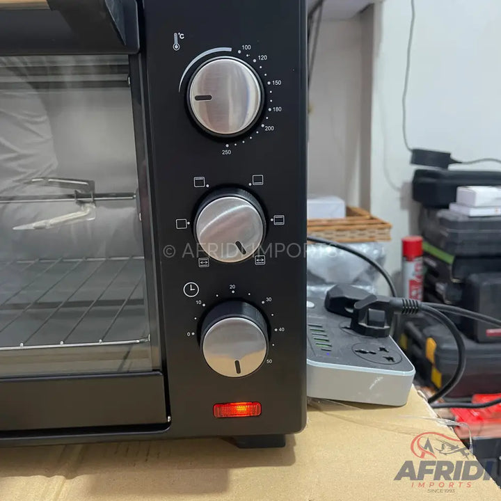Black electric toaster oven with three control knobs and a clear glass door.