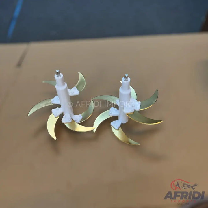 Two shiny golden-bladed food chopper attachments with white plastic shafts.