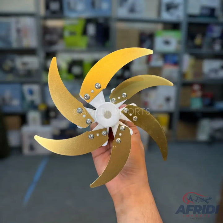 A six-bladed gold-colored metal fan propeller with a white plastic hub.