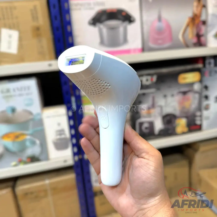 A handheld white IPL hair removal device with a blue light window.