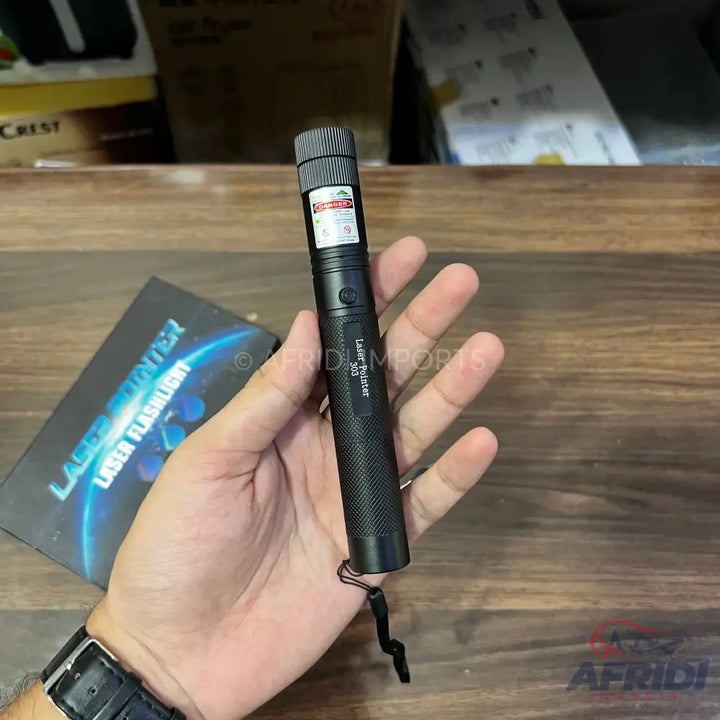 A black laser pointer with a textured grip and a wrist strap.