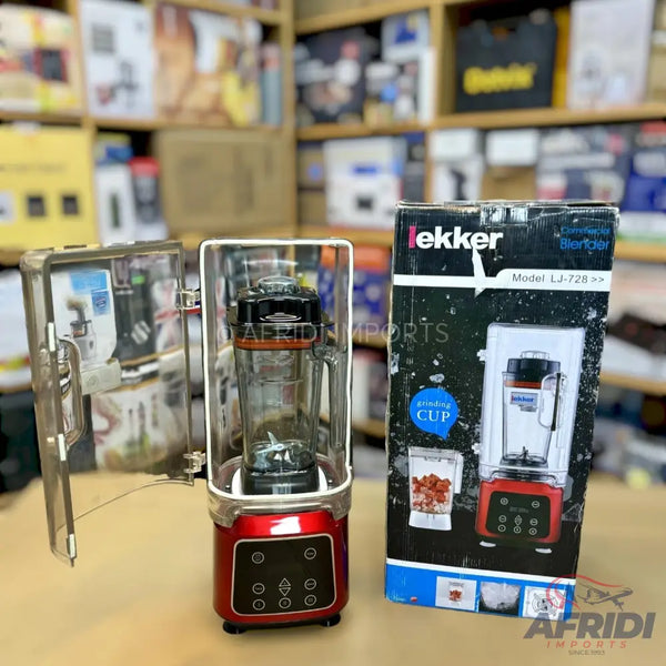 Red and black countertop blender with a clear jar and a digital control panel, packaged in a box.