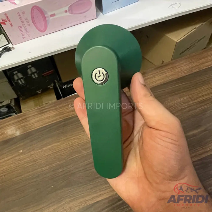 A green handheld lint remover with a power button.