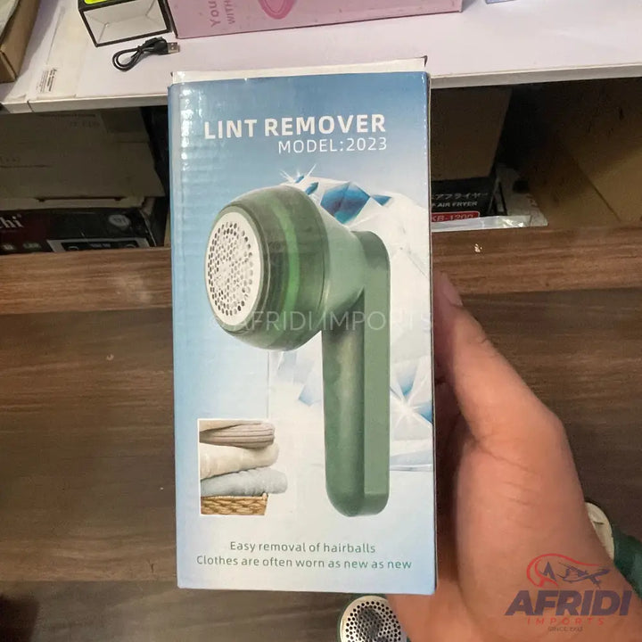 Green lint remover with a white mesh head.