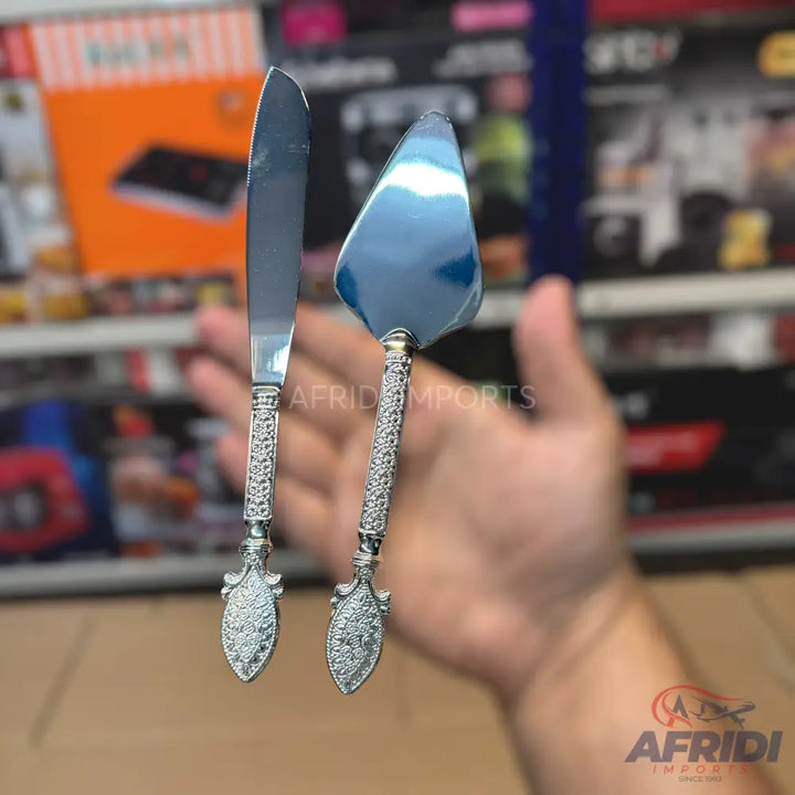 A decorative silver-colored cake knife and server set.