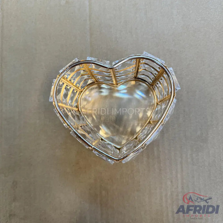 A heart-shaped crystal basket with a golden interior lining.