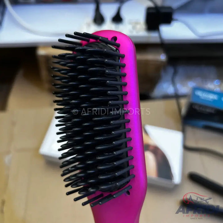 A hot pink hairbrush with black bristles.