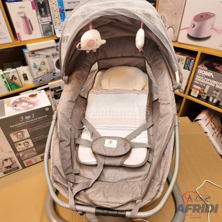 Grey baby bassinet with a canopy, hanging toys, and a five-point harness.