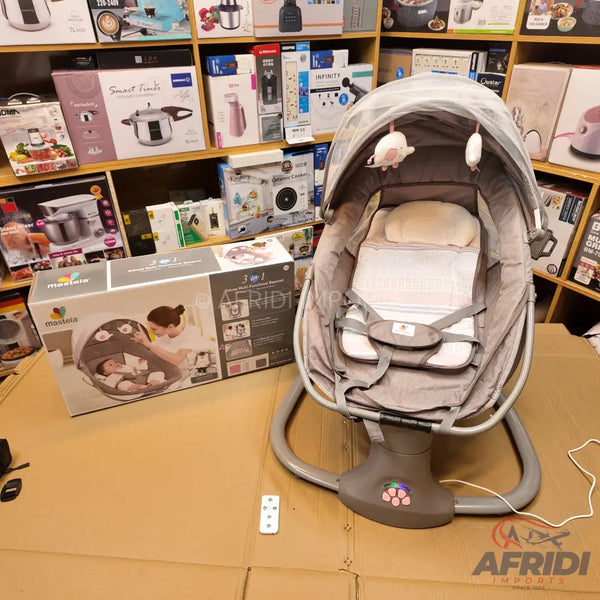 A gray baby swing with a canopy, mobile, and safety harness, accompanied by its packaging box and a remote control.