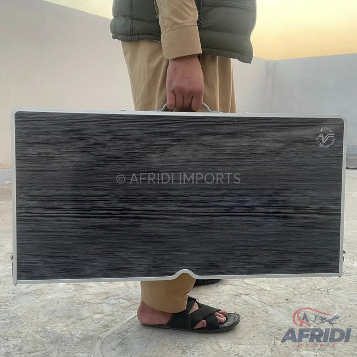 Foldable dark gray portable table with a handle.