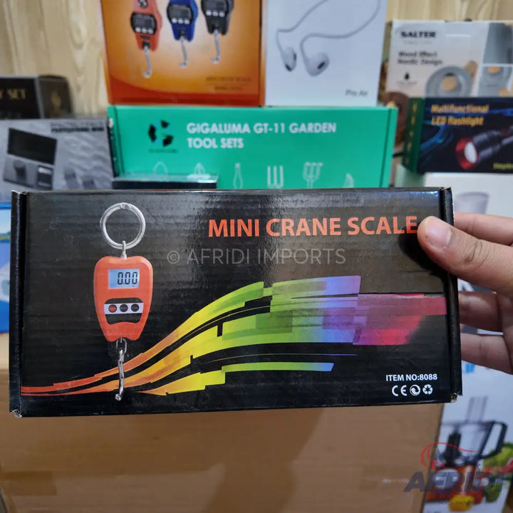 Miniature digital crane scale with a hook and keyring.