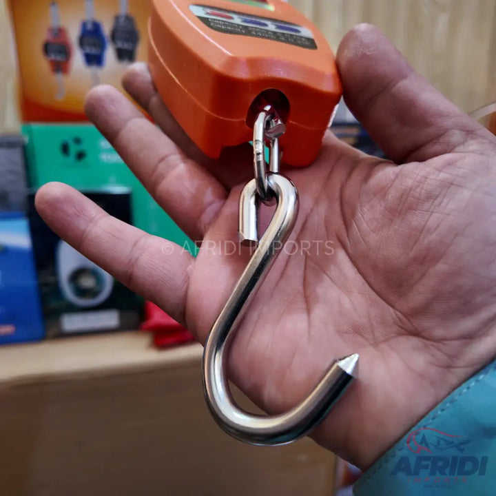 Orange handheld digital weighing scale with a metal hook.