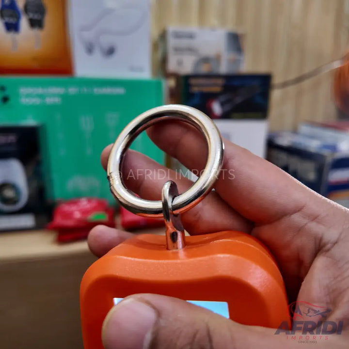 Orange portable electronic device with a metal ring for attachment.