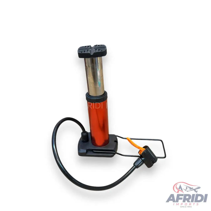 A portable red and silver bicycle pump with a black hose and foot stand.