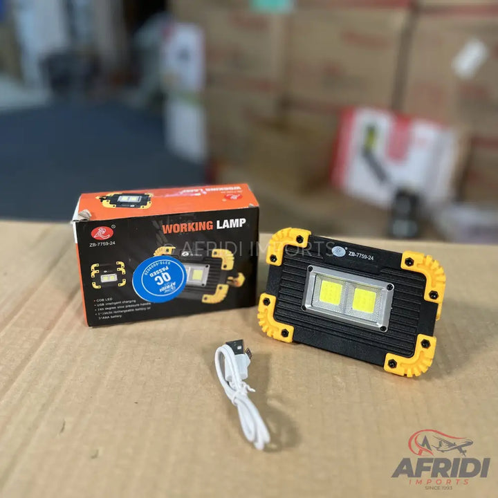 A black and yellow portable working lamp with two bright LED lights and a charging cable.