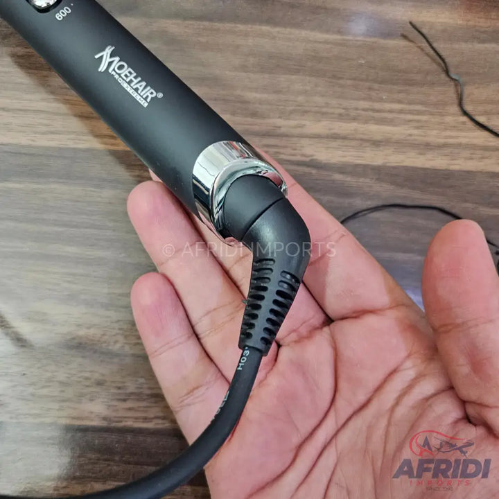 Black hair styling tool with a rotating cord.